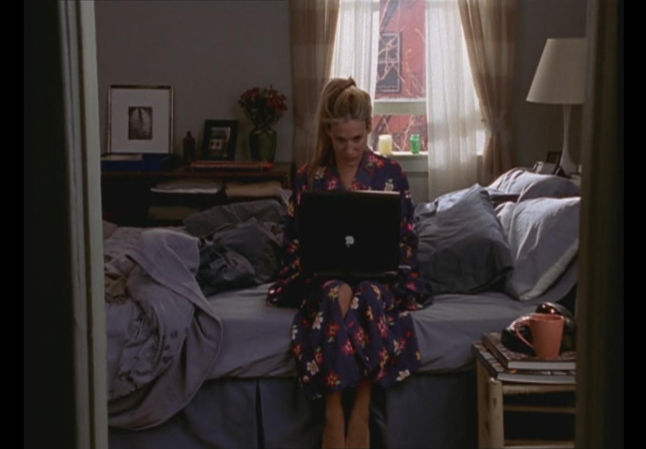 Passion of Arts, Carrie Bradshaw sitzt auf ihrem Bett und schreibt auf ihrem Laptop an ihrer Kolumne. liebsten, weiblichen Seriendarstellerinnen 2021? 